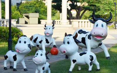 戶外小區(qū)一群玻璃鋼卡通奶牛雕塑