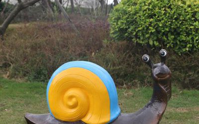 草地上擺放的小眼睛的玻璃鋼彩繪蝸牛雕塑